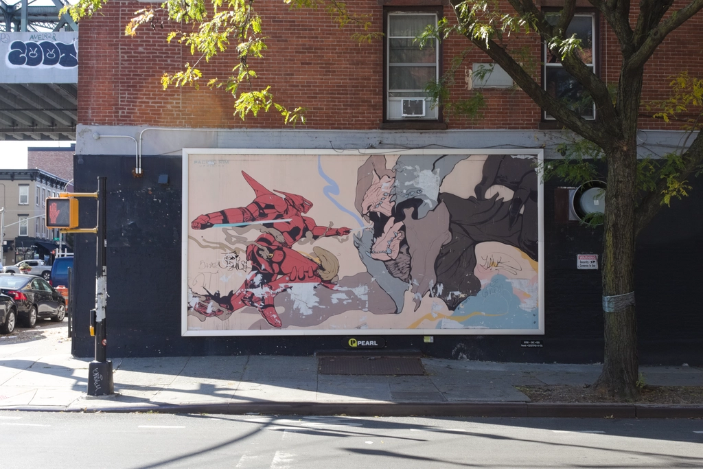 A poster for the Pacific Rim movie, featuring a robot fighting a giant moster. It is in the shade, framed by a tree, sidewalk, crossing signal, and red brick above.